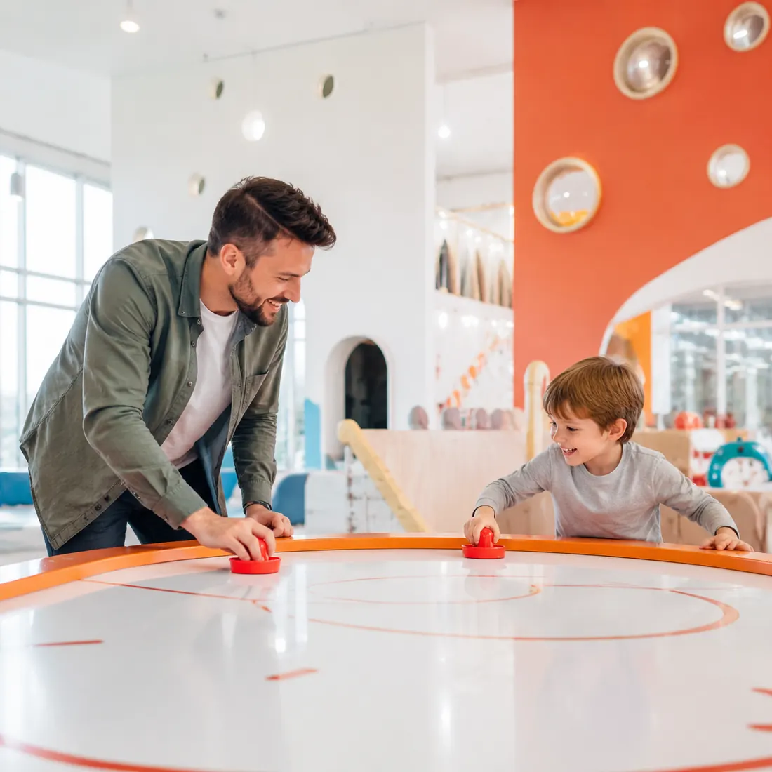 Padre e hijo jugando hockey de mesa en el arcade familiar