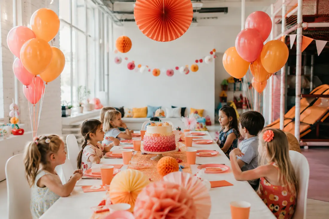 Mesa decorada para cumpleaños infantil con globos color coral
